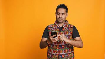 Happy man playing videogames on smartphone, celebrating after defeating foes, doing clenching hand gesture. Player swiping phone screen, thrilled about winning game, studio background, camera B photo