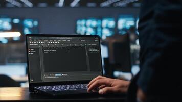 IT support employee typing on notebook keyboard to ensure optimal performance in data center. Close up shot of laptop used by worker monitoring energy consumption across servers photo