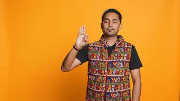 Indian man doing ok hand sign, feeling pleased, agreeing with satisfactory conclusion. Optimistic person doing okay symbol gesturing, offering positive feedback, studio background, camera B photo
