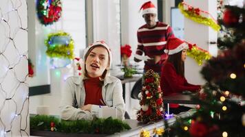 retrato de alegre mujer en Navidad decorado oficina participativo en empresa vlog para márketing social medios de comunicación canal, saludo espectadores y reír, disfrutando Navidad festivo estado animico foto