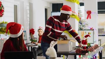 contento africano americano empleado claro festivo decorado oficina escritorio antes de dejando para vacaciones. trabajador vistiendo Papa Noel sombrero tomando dias apagado a Vamos en Navidad día festivo, sensación alegre foto