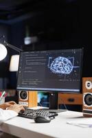 Selective focus of desktop PC showing a futuristic interface for Muslim guy to work on cybersecurity. Male person monitors a network and manages a supercomputer connected to a data center. photo