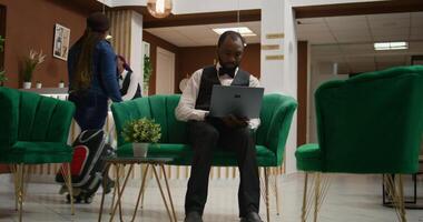 Hospitality industry employee. Bellhop processing data from registration forms in lounge area, hotel concierge making entry on list of guests to assign right rooms, clipboard notes. photo