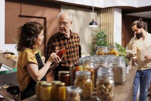 Father and daughter shopping in zero waste store looking for locally sourced bulk products. Family members purchasing pantry staples from local neighborhood shop with zero carbon dioxide emissions photo