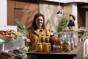 Portrait of smiling woman looking for fresh vegetables in eco friendly zero waste store. Happy customer doing grocery shopping, buying organic bio food items in local neighborhood store photo