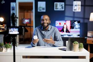 Content creator filming tech tutorial on how to do smart light bulb maintenance. Man providing viewers with step-by-step guide to keep home automation gadget running smoothly photo