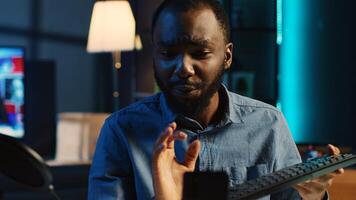 African american technology internet star filming review of newly released wireless keyboard, greeting audience and presenting them feedback about typing experience, doing endorsement photo