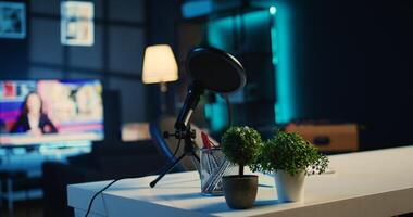Empty home studio interior with professional recording devices used for internet show production. Apartment filled with content creation equipment, TV running in background, close up photo