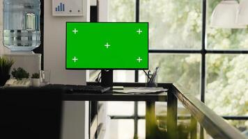 Empty desk with greenscreen layout presenting blank copyspace template in agency coworking space. Office workstation running computer monitor with isolated chromakey screen, modern software. photo