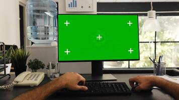 POV of man at desk works with greenscreen and isolated copyspace template, solving business tasks. Company manager sitting at workstation looking at blank chromakey screen. Tripod shot. photo