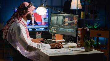 Arabic cinematographer in home office editing project using filmmaking techniques, working with footage and sound. Middle Eastern man using videography software to process movie on workstation photo