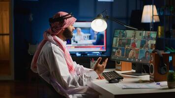Muslim team leader holding online conference meeting with remotely working subalterns, checking on task progress. Middle Eastern business executive discussing with employees during call photo