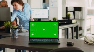 Urban coworking space desk with greenscreen design and copyspace on display at empty seat. Chromakey screen technology is used by smaller enterprises, isolated mockup layout on laptop. photo