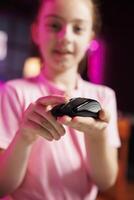 Close up shot of young media star in studio reviewing gaming mouse in front of camera in personal studio. Cheerful kid filming electronics haul, pressing buttons to test wireless computer peripheral photo