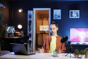 Kid content creator using professional recording equipment to film vlog channel intro for online streaming platforms. Young media star greets fanbase, presenting today topic photo