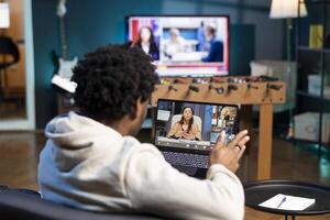 Teleworker and coworkers in teleconference crosschecking analytics statistical data sets from apartment office. Remote employee optimizing key performance indicators with colleagues in videocall photo