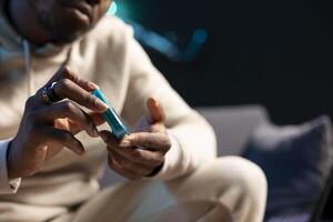 Close up shot of pulse oximeter used by man to monitor level of blood oxygen saturation and heart rate. Focus on medical instrument used by person in blurry background doing annual checkup at home photo