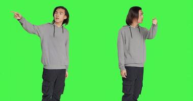 Adult showing left or right directions in studio, pointing to both sides and recommending another walkway. Asian young person indicating persons to go that way using index fingers. photo