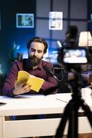 Experienced voice actor in studio working on audiobook recording production, reading from book, capturing sound with professional mic and filming with high quality equipment camera photo