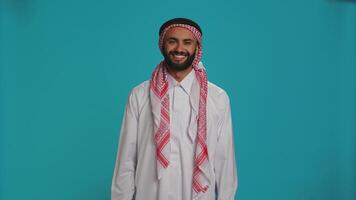 Arab person says yes and nodding on camera, presenting agreement and support about something. Middle eastern man expressing positivity and confidence, showing agreement. photo