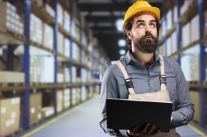 Supervisor working on cargo and merchandise inventory, verifying all stock labels and dispatch notes. Depot manager ensuring perfect supply chain operations, responsible with goods distribution. photo