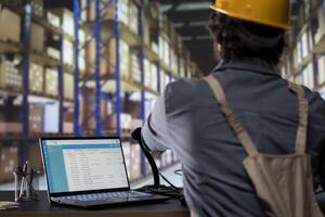 Logistics engineer drafting dispatch notes for an order shipment, managing transport and delivery requirements. Warehouse operator reviewing invoices or receipts for stock control and submission. photo