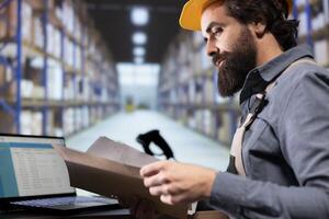 Depot engineer reviewing distribution contract details on files, verifying all cargo invoices and consignment notes. Warehouse manager working on supply chain management and shipments. photo