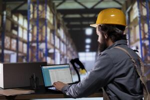 Warehouse employee doing quality control on products, preparing merchandise for shipment and registering consignment note for orders. Depot manager examining distribution details on pc. photo