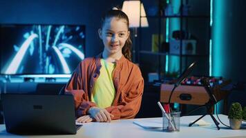 Kid content creator using recording devices to shoot intro for family vlog channel on online platforms. Cute child internet star warmly welcoming dedicated gen Z viewers, filming in home studio photo