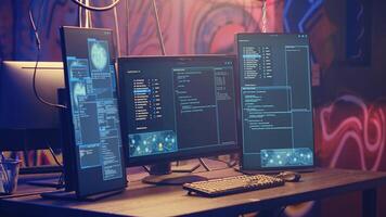 Close up shot on computer screens with hacking lines of code in hidden underground HQ. PC monitors in graffiti painted abandoned warehouse used by hackers to escape from being arrested by police photo