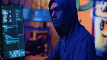 Asian hacker in dark hidden shelter trying to launch DDoS attack on website by sending large amounts of traffic from multiple sources to overwhelm it. Evil computer scientists flooding target server photo
