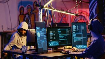 Hackers in secret bunker with graffiti walls writing code that spoofs their location, tricking cops. Rogue programmers running script pinging wrong location to cybercriminal law enforcement photo