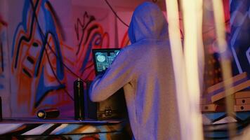 Close up shot of hacker in underground bunker using network vulnerabilities to exploit servers, trying to break computer systems at night. African American cybercriminal breaching networks photo
