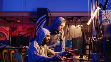 Hackers brainstorming ways of using network vulnerabilities to exploit servers, trying to break computer systems at night. Rogue developers work together on breaching networks photo