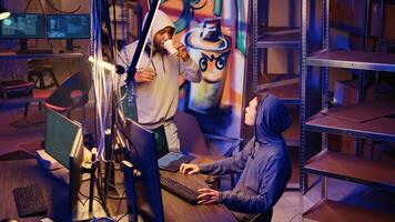 Teamworking hackers in graffiti painted hideout targeting vulnerable unpatched connections, seeking to compromise digital devices and steal valuable sensitive information from them photo