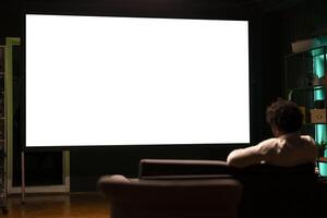 Person using isolated screen ultrawide smart TV to binge series on subscription based streaming services. African american man relaxing, enjoying on demand shows on mockup television display photo