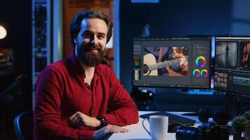 Portrait of happy editor merging raw clips and footage into high quality finished videos in production studio. Videographer using specialized software application and editing tools photo