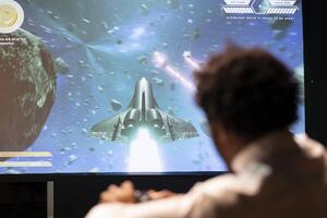 Man playing competitive spaceship racing videogame in apartment, holding joystick. Gamer participating in online multiplayer tourney using professional controller to better navigate photo