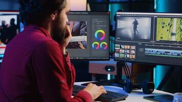 Professional editor analyzing film montage before editing color grading and lighting in creative office. Post production studio employee working with raw footage, improving quality photo