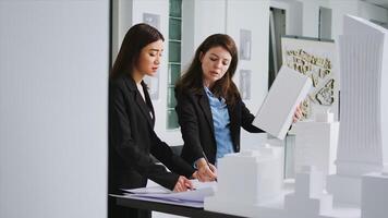 Manufacturing engineers looking at building model shape to create the perfect measurements for property remodeling. Architectural experts team working with industrial tools at creative agency. photo