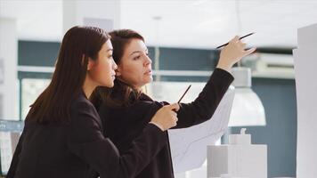 Design group interprets dimensions working in real estate brokerage headquarters. Planners team create schematics and patterns for constructors, contributing to production stage. photo
