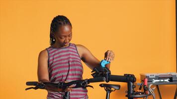 Engineer setting up bike repair stand, using it to adjust derailleur and cables, fixing broken wheels, studio background. Professional assembling workstand to maintain bicycle at eye level, camera A photo