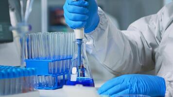 Close up of researcher testing liquid sample using micropipette for new treatment medical laboratory. Team of doctors examining virus evolution using high tech for vaccine development against covid19 photo