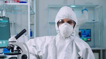 Portrait of overworked biolog looking at camera in modern equipped lab. Team of scientists examining virus evolution using high tech and chemistry tools for scientific research, vaccine development. photo