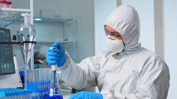Laboratory scientist working in modern lab with test tubes and micropipette. Team of chemists examining virus evolution using high tech for scientific research of treatment development against covid19 photo