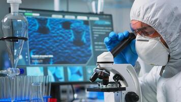 Close up of man scientist looking through a microscope in modern equipped lab. Lab technician examining virus evolution using high tech for scientific research of treatment development against covid19 photo