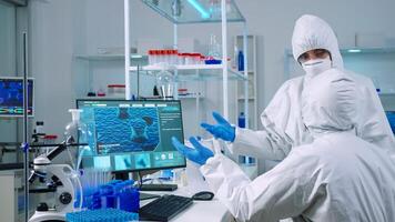 Team of chemists in coverall working to develop vaccine in equipped laboratory. Scientists examining virus evolution using high tech for scientific research of treatment development against covid19 photo