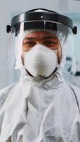 Portrait of scientist man wearing coverall smiling at camera sitting in modern equipped laboratory. Chemist doctor xamining virus evolution using high tech for scientific research, vaccine development photo