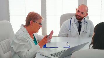 Medical experts having health seminar in hospital conference room, discussing about symptoms of patients. Clinic therapist talking with colleagues about disease for treatment development. photo