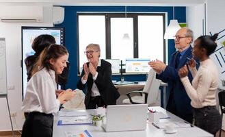 Happy diverse colleagues with new business opportunity enjoing victory. Multiethnical partners coworkers celebrate successful teamwork result at company briefing photo